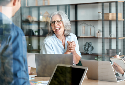 Female supervisor laughing during a meeting.